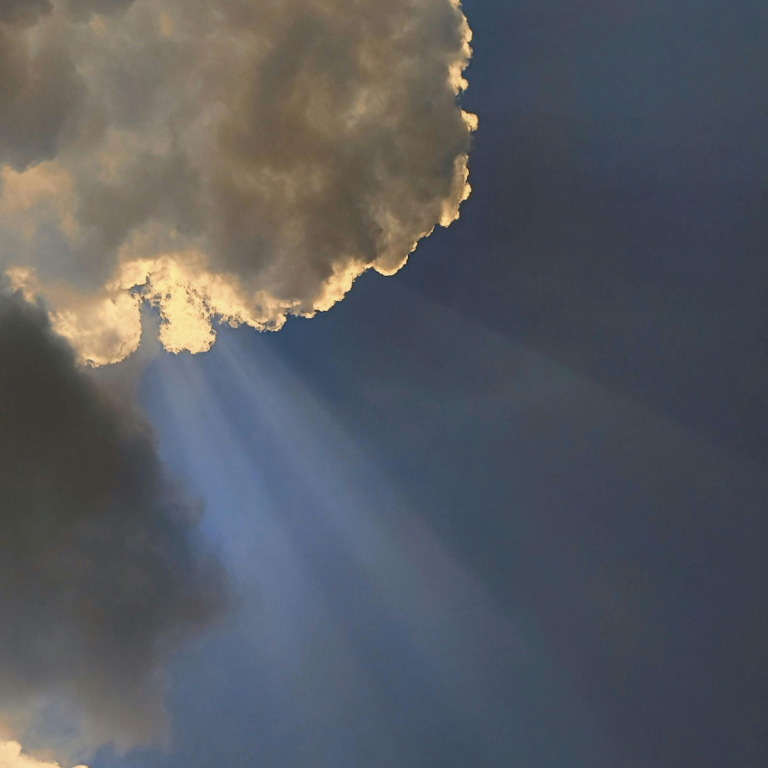 Strahlen der Sonne durch Wolken in einem blauen Himmel.